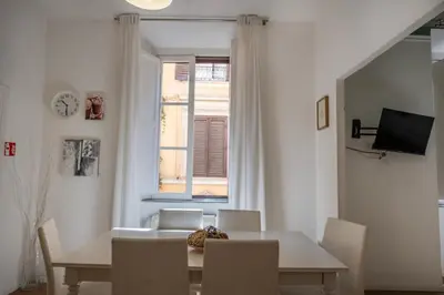 a dining room with a table and chairs and a window at Apartment by the Colosseum - White Chic Flats in Rome