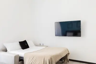 a room with a couch and a tv on a wall at A World Aparts - 23 Artisti in Rome