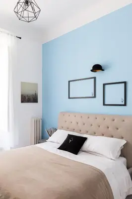 a bedroom with a large bed with blue walls at A World Aparts - 23 Artisti in Rome