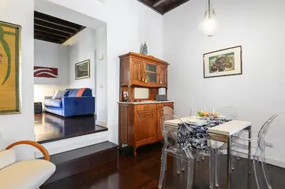 a living room with a table and a blue couch at Delizioso appartamento a Campo de' Fiori in Rome