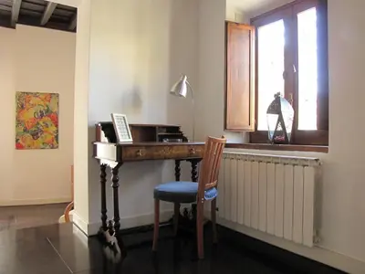 a desk in a room with a chair and a window at Delizioso appartamento a Campo de' Fiori in Rome