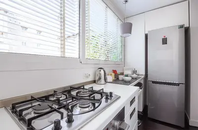 a white kitchen with a stove and a refrigerator at Delizioso appartamento a Campo de' Fiori in Rome