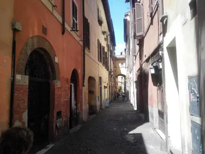 an alley with buildings and a person walking down the street at Delizioso appartamento a Campo de' Fiori in Rome