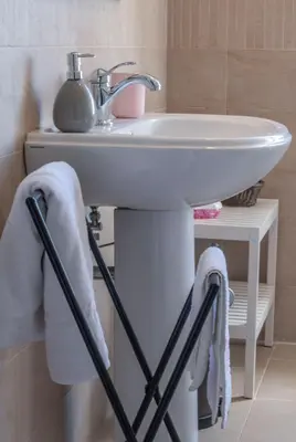 a bathroom with a sink with towels hanging from it at Campo24roma Guesthouse in Rome