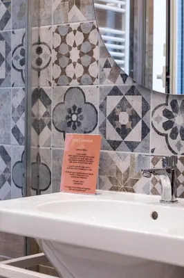 a bathroom with a sink with a sign on it at Campo24roma Guesthouse in Rome