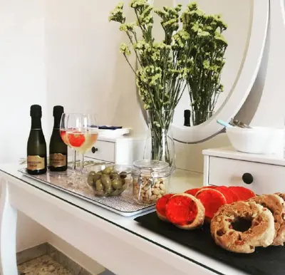 a table with a tray of bread and drinks and a mirror at Campo24roma Guesthouse in Rome