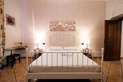 a bedroom with a bed with two tables and two lamps at Magna Domus in Rome