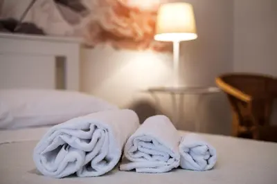 a pile of towels sitting on top of a bed at Magna Domus in Rome