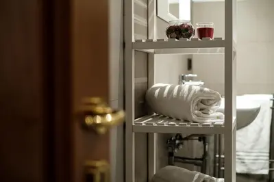 a towel shelf in a bathroom with a sink at Magna Domus in Rome