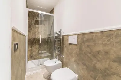 a bathroom with a white toilet and a shower at Loft Farnese 1 suite luxury area soggiorno e cucina in Rome