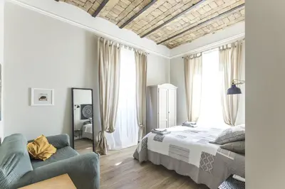 a bedroom with a bed and a couch and windows at Casa di Ele in Rome