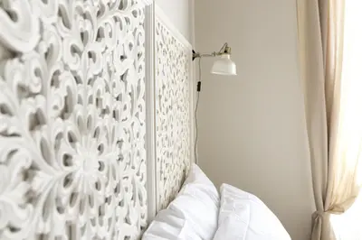 a bedroom with a white headboard and a bed at Casa di Ele in Rome