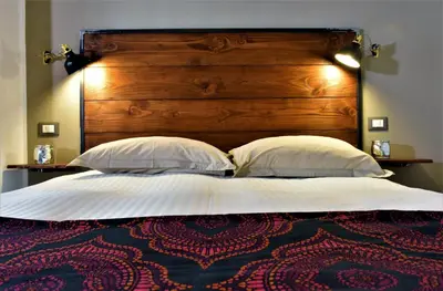 a large bed with a wooden headboard and two pillows at Miriam Apartment in Rome