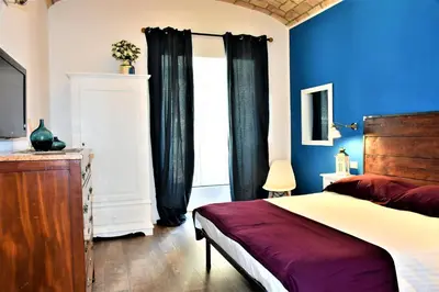a bedroom with blue walls and a bed and a window at Miriam Apartment in Rome