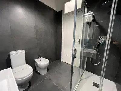 a bathroom with a toilet and a glass shower at Miriam Apartment in Rome
