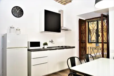 a kitchen with a white refrigerator and a table with chairs at Miriam Apartment in Rome