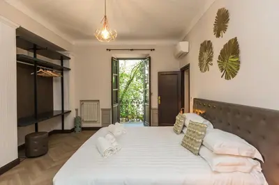 a bedroom with two beds and a large window at Beyond Colosseum in Rome