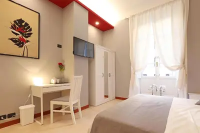 a bedroom with a bed and a desk and a television at Olafo’s house in Rome