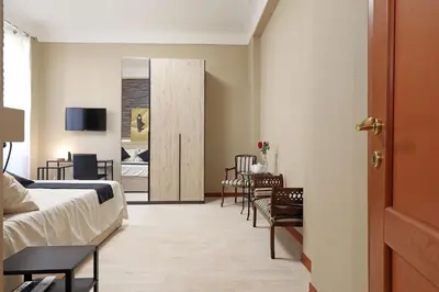 a bedroom with a bed and a table and chairs at Olafo’s house in Rome