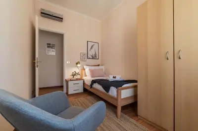a bedroom with a bed and a blue chair at Augustus Suite near Saint Peter in Rome