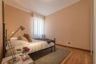 a bedroom with a bed and a table with a lamp at Augustus Suite near Saint Peter in Rome
