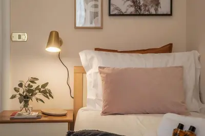 a bed with a pillow and a table with a lamp at Augustus Suite near Saint Peter in Rome
