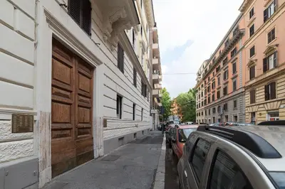 a building with a wooden door and cars parked on a street at Augustus Suite near Saint Peter in Rome