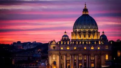 a building with a dome on top at sunset at Augustus Suite near Saint Peter in Rome