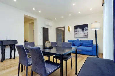 a living room with a blue couch and a table and chairs at Houses&HousesVEDOROMA in Rome