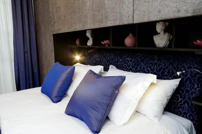 a bedroom with a bed with blue and white pillows at Houses&HousesVEDOROMA in Rome