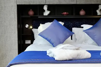 a bed with blue and white pillows on it at Houses&HousesVEDOROMA in Rome