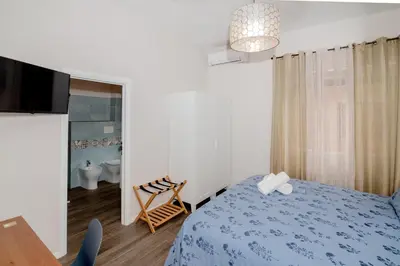 a bedroom with a blue bed and a bathroom at La RomAntica Roma in Rome
