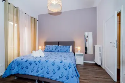 a bedroom with a bed with a blue comforter at La RomAntica Roma in Rome