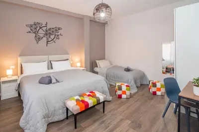 a bedroom with two beds and a table at La RomAntica Roma in Rome