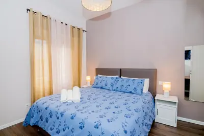 a bedroom with a blue bed with two candles on it at La RomAntica Roma in Rome