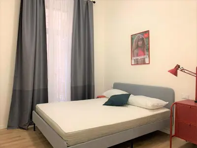 a bed sitting in a room with a window at Cozy flat in Rome in Rome
