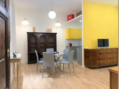 a kitchen with white cabinets and a table and a sink at Cozy flat in Rome in Rome