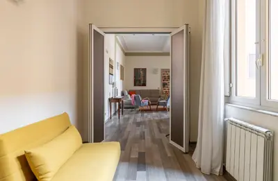 a living room with a yellow couch and a window at HospitalityRome Domus Aureliana in Rome