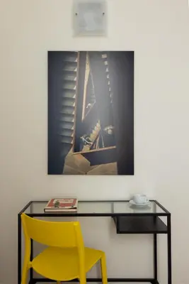 a desk with a yellow chair and a picture on the wall at HospitalityRome Domus Aureliana in Rome