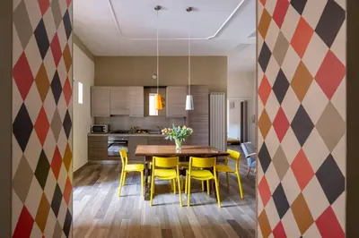 a kitchen and dining room with a table and yellow chairs at HospitalityRome Domus Aureliana in Rome