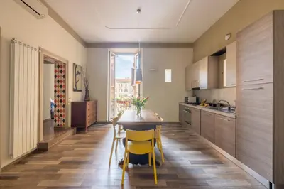 a kitchen with a wooden table and yellow chairs at HospitalityRome Domus Aureliana in Rome