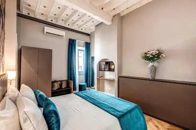 a bedroom with a bed and a vase of flowers at Maison d'Art Apartments - Maison d'Art Collection in Rome