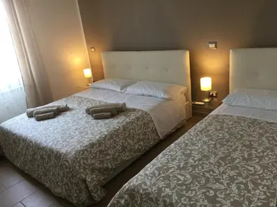 two beds in a hotel room with towels on them at Casa Grimaldi in Rome