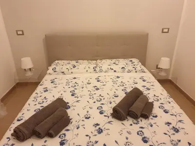 a bed with two pillows and towels on it at Casa Grimaldi in Rome