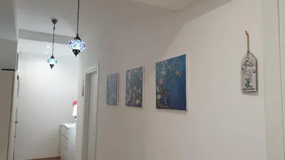 a hallway with four paintings on a wall at Casa Grimaldi in Rome