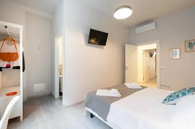 a bedroom with a bed and a tv on the wall at Winkler Suites in Rome