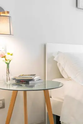 a glass table with books on it next to a bed at Winkler Suites in Rome