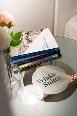 a table with two books and a vase with flowers at Winkler Suites in Rome