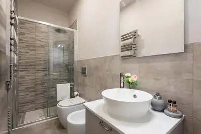 a bathroom with a white sink and a toilet at Winkler Suites in Rome
