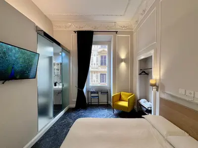a hotel room with a bed and a yellow chair at Room Roma Nazionale in Rome